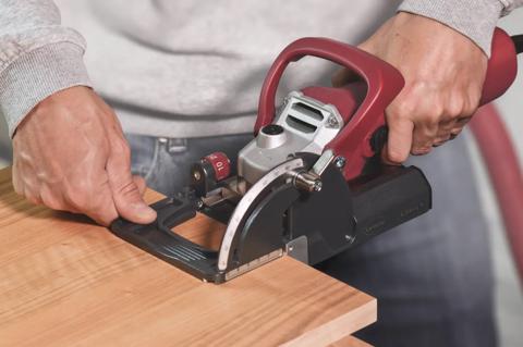 Lamello Classic X biscuit joiner in use, cutting a slot in a wood panel