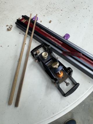 A finished pair of tapered chopsticks next to the Bridge City block plane and the jig track