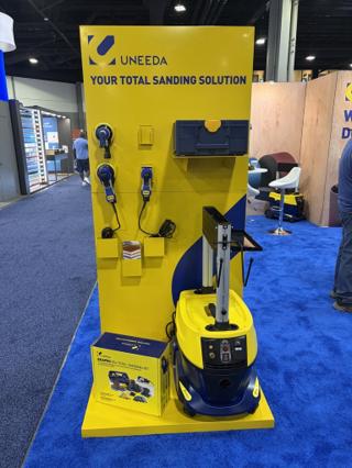 UNEEDA booth display headed Your Total Sanding Solution, with blue EKASAND sanders on the wall, the systainer mounted above them, and a yellow and blue EKASAND Series 2 dust extractor with an EKAPRO 3x4 Total Sanding Kit box at its base