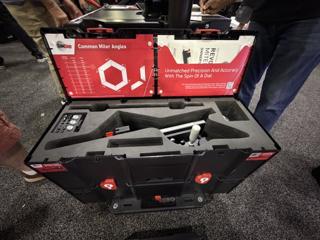 Black Systainer³ XXL 237 open on a cart at the SawStop booth, holding the Revolution Miter Gauge, its fence extrusion and small parts in die-cut foam, with a Common Miter Angles reference chart and an owner's manual pocket in the lid