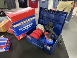 Blue systainer open on a table labelled 5 inch, holding a blue SurfPrep 5 inch random orbital sander with its cord coiled, a stack of red foam-backed abrasive discs and a grey foam block behind a divider