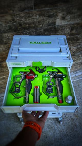 A red Titan RX-Pro and a black Wagner Vector Pro airless spray gun seated side by side in a green 3D-printed insert in the top Sortainer drawer