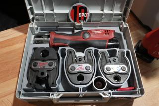 Overhead view of the insert: the M12 press tool across the back, three press jaws in individual pockets in front, and a tube reamer in a round pocket