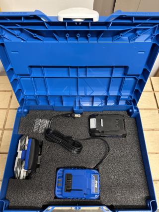 The same sky blue M 237 with a black Kaizen foam layer in it, with pockets cut for the Kreg Blue Ion charger with its coiled cord, a 20V battery and the narrow stock guide
